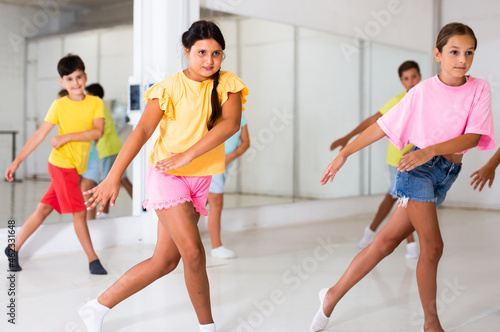 Children studying modern style dances in dance class indoors