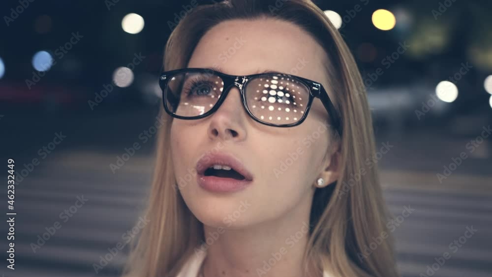 The attractive woman in glasses standing at the night street. slow motion The attractive woman in glasses standing at the night street. slow motion