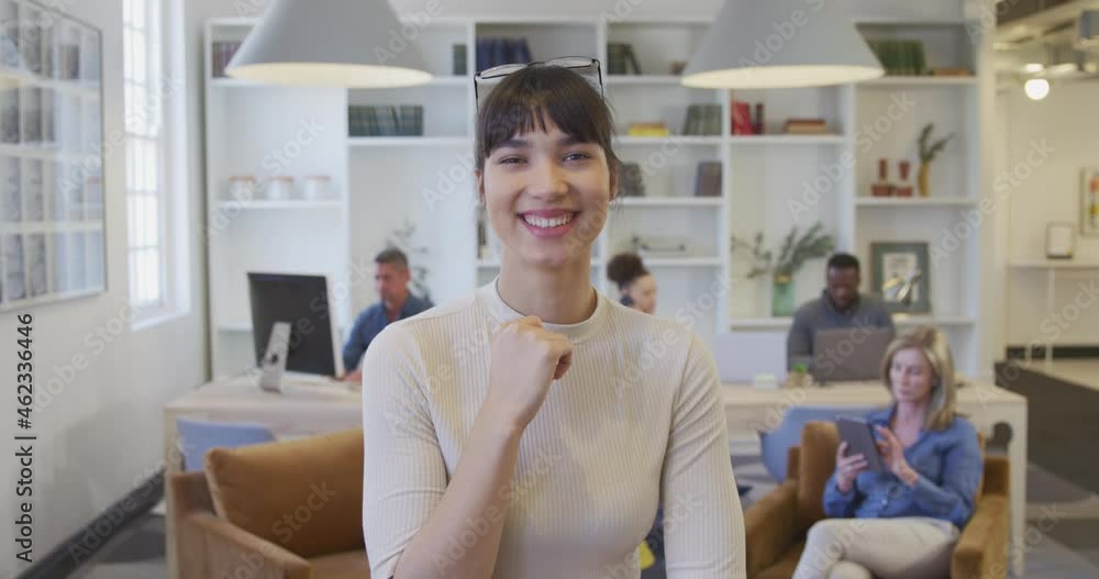 Young woman smiling to camera at the office Young woman smiling to camera at the office