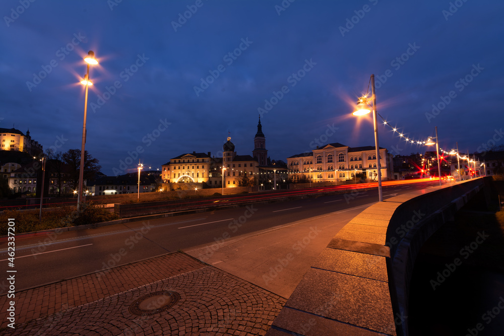 Obraz premium colorful light stripes of cars on the street at night in front of a church in the city of plauen