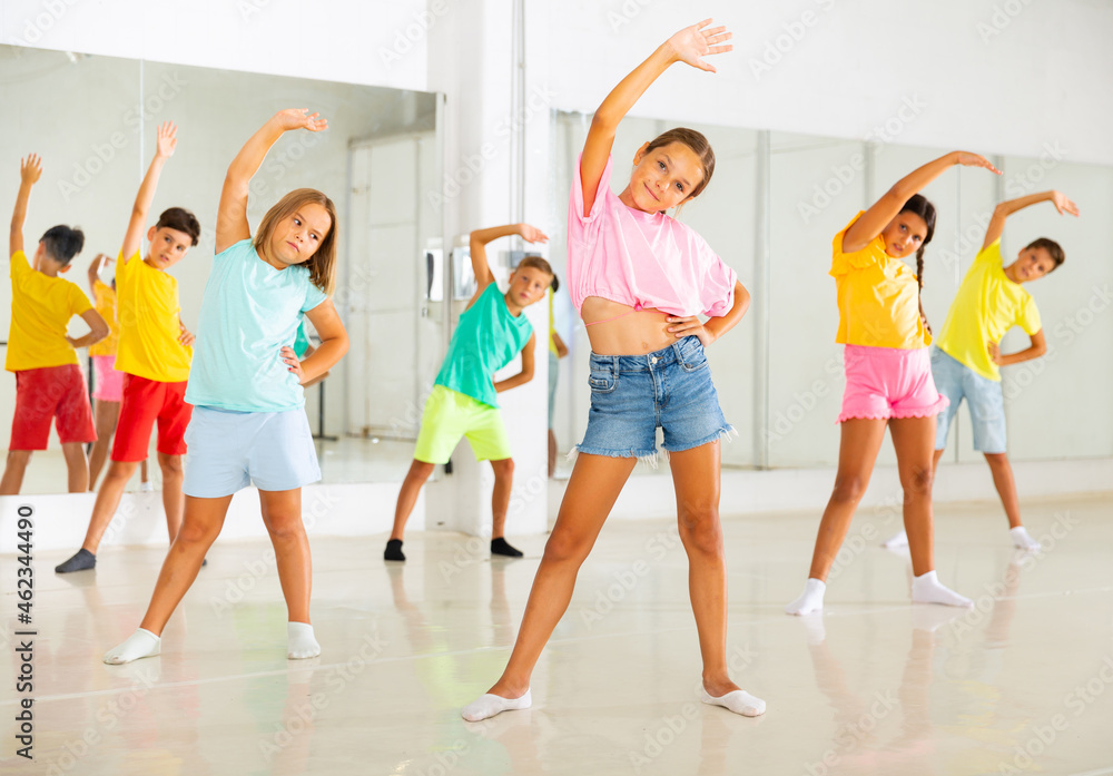 Group of kids training dance moves together in studio.