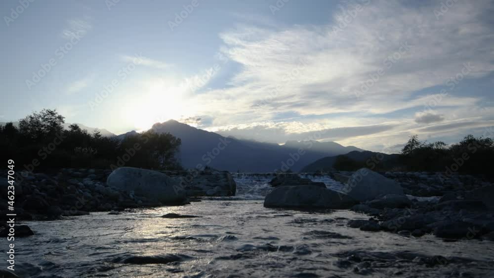 Silhouette of mountains and a river at sunset. Tracking to left Silhouette of mountains and a river at sunset. Tracking to left