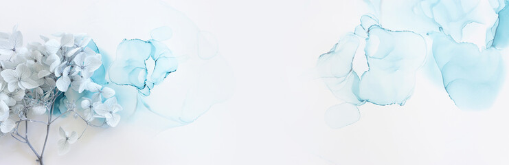 Creative image of pastel blue Hydrangea flowers on artistic ink background. Top view with copy space
