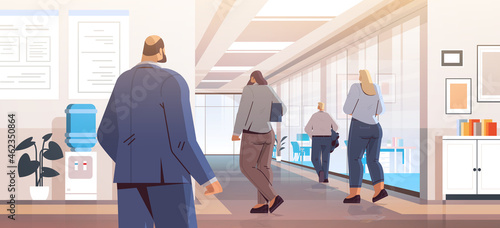 businesspeople standing back to camera rear view of business people group in office corridor