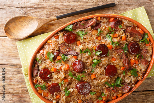 Foto Portuguese duck rice arroz de pato cooked with red wine, onion, carrot and chorizo close up in the baking dish on the wooden table