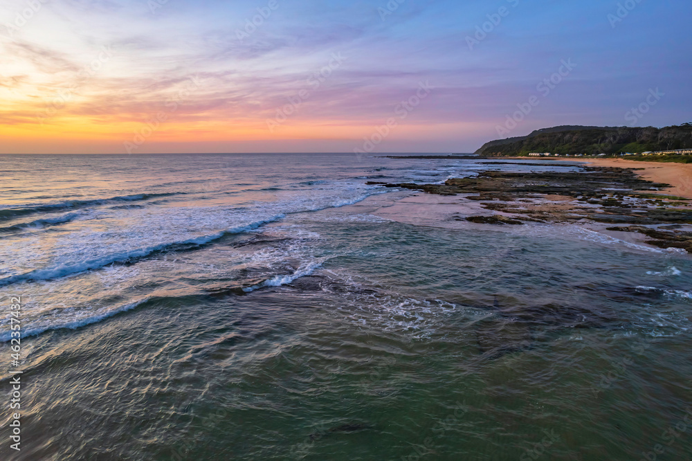 Naklejka premium Aerial dawn seascape with high cloud and gentle surf