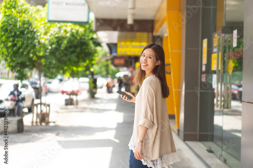 Young adult business asian woman walking in public outdoor.