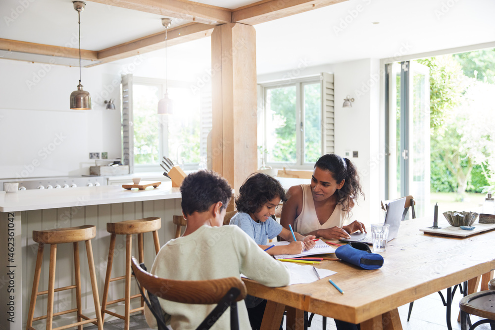 Mother with sons doing homework in kitchen Mother with sons doing homework in kitchen