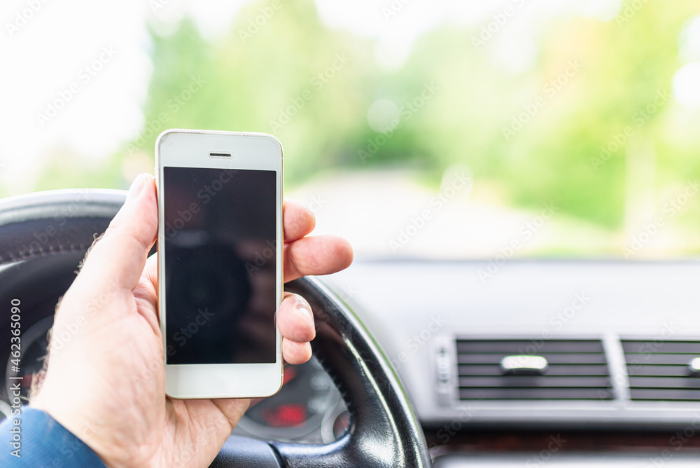 Man hand holding screen smart phone, blur on the road high way forest summer background.copy space,advertisement,banner.