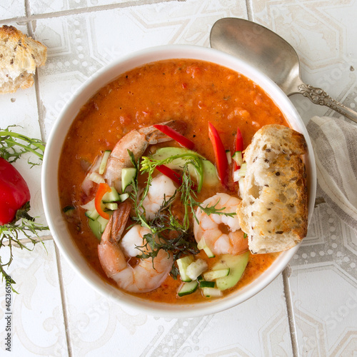 bowl of gazpacho with shrimps on a light table