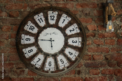 a clock and lamp hanging on a red brick wall. Selective Focus Clock