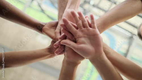 Video of close up of hands of successful smart business team celebrating good job while holding up their right hands on coworking place.