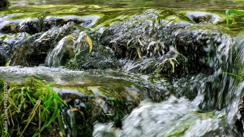 Mountain river of transparent waters with trees and abundant moss on the rocks. Beautiful waterfall in green forest in jungle. Wild mountain river with small waterfalls running through the forest