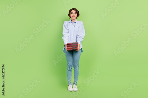 Full body photo of young woman happy positive smile hold book education isolated over green color background © deagreez