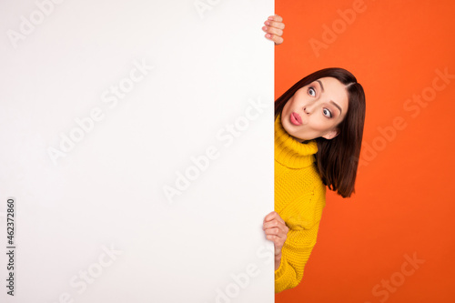 Photo of young woman amazed shocked look empty space blank poster advertise news isolated over orange color background