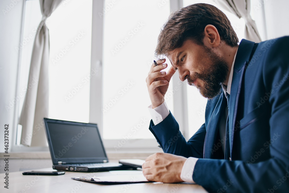 businessmen sitting at a desk in front of a laptop finance businessmen sitting at a desk in front of a laptop finance