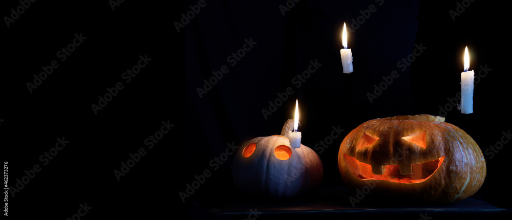 Halloween pumpkin with spooky glow with candles on dark background Halloween pumpkin with spooky glow with candles on dark background