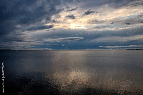  cloudscape or waterscape. Calm waveless lake mirror surface reflects beautiful clouds in evening summer sunset light