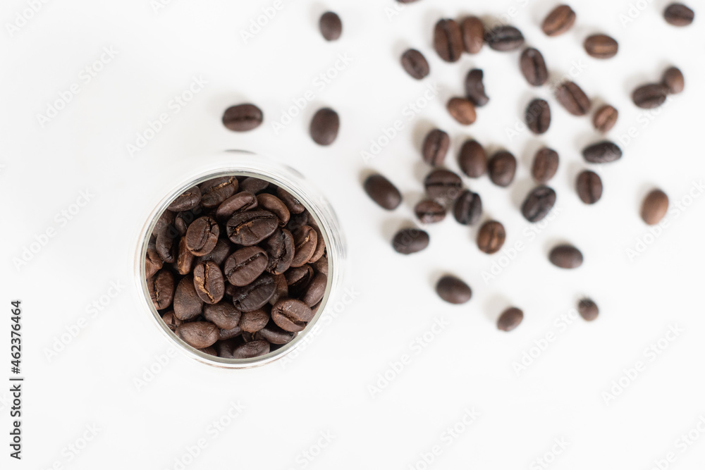 Roasted coffee beans in clear glass on white background. Roasted coffee beans in clear glass on white background.