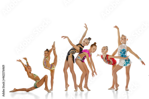 Six girls, little beautiful rhythmic gymnastics artists in group sport event isolated on white studio background. Concept of action, team, show