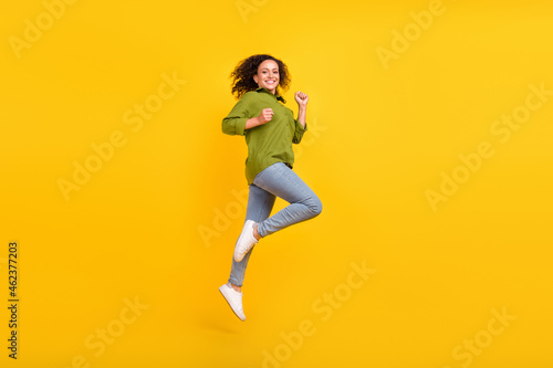 Fototapeta Naklejka Na Ścianę i Meble -  Photo of attractive funny funky positive trendy lady wear green shirt running jumping high isolated yellow color background