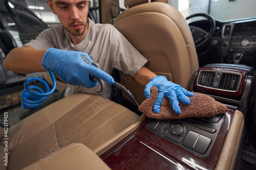 Car washman worker cleaning vehicle at renewing service station shop photo