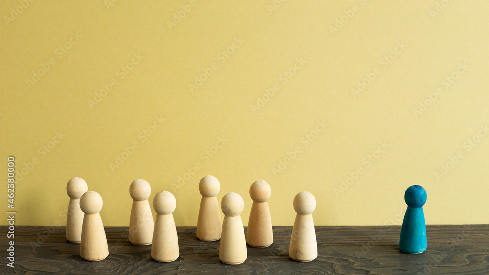 Majority vs minority concept. Wooden human figure on desk. brown background