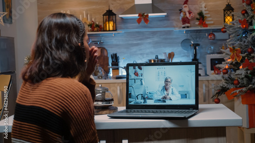 Sick young woman using telemedicine on laptop for medical prescription from doctor. Patient asking about healing treatment to cure disease for christmas eve dinner celebration party