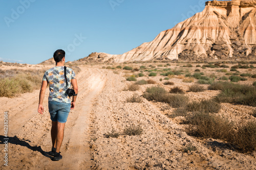 Young man with a camera in Bardenas Reales desert  Navarra  Basque Country.