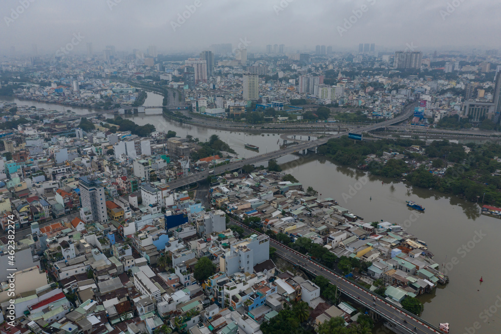 Ho Chi Minh City, Vietnam morning drone shot over junction of Kenh Te, Ong Lon and Ben Nghe canals, working river boats and district four and eight waterfront architecture, rooftops and bridges