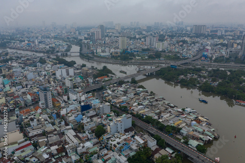 Ho Chi Minh City  Vietnam morning drone shot over junction of Kenh Te  Ong Lon and Ben Nghe canals  working river boats and district four and eight waterfront architecture  rooftops and bridges