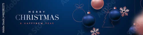 Merry Christmas and Happy New Year vector banner. Realistic rose gold and blue baubles, snowflakes hanging on dark blue background. Christmas balls motion blur effect. Luxury background.