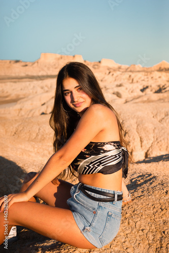 Young caucasian woman posing in Bardenas Reales desert at sunset time. Navarra, Basque Country.