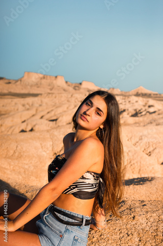 Young caucasian woman posing in Bardenas Reales desert at sunset time. Navarra, Basque Country.