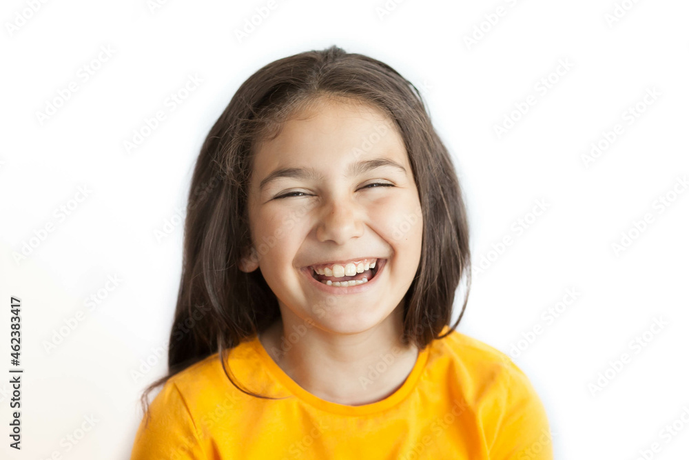 Happy positive smiling child girl with a long hair in yellow T-shirt isolated on white background Happy positive smiling child girl with a long hair in yellow T-shirt isolated on white background
