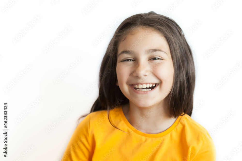 Happy positive smiling child girl with a long hair in yellow T-shirt isolated on white background Happy positive smiling child girl with a long hair in yellow T-shirt isolated on white background