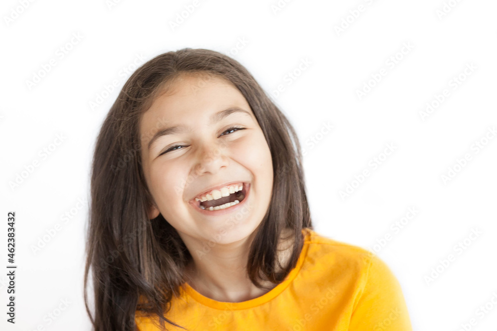 Happy positive smiling child girl with a long hair in yellow T-shirt isolated on white background Happy positive smiling child girl with a long hair in yellow T-shirt isolated on white background