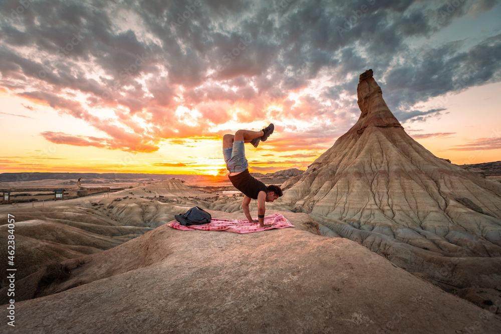 Young caucasian man in front of Castildetierra natural monument while sunset at Bardenas Reales desert, Navarra, Basque Country.