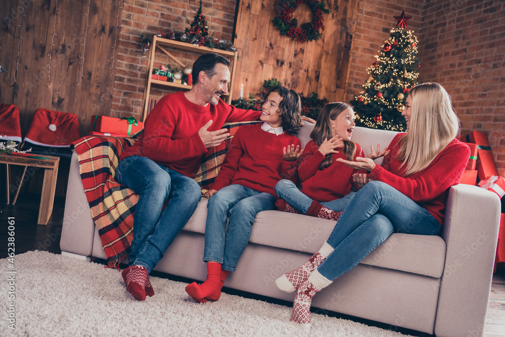 Portrait of beautiful handsome cheerful family dad mom sitting on sofa chatting advent at decorated loft home indoors Portrait of beautiful handsome cheerful family dad mom sitting on sofa chatting advent at decorated loft home indoors