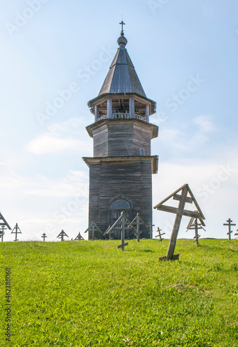 The tent-roofed bell tower of the Kizhi churchyard against the background of crosses. Kizhi Island. Republic of Karelia. Russia photo