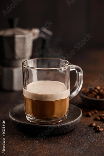 a cup of coffee on a dark table, coffee beans
