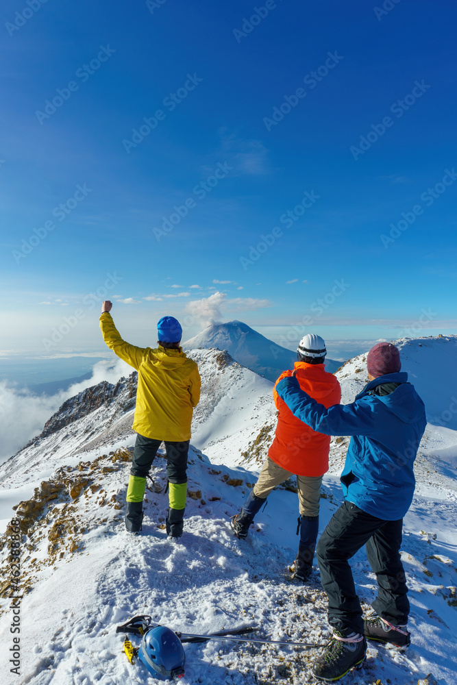 friends stands on mountain top and looks at mountains