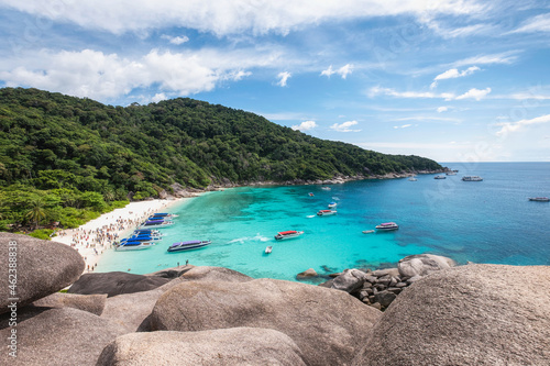 Similan island with tourists traveling on the beach in tropical sea