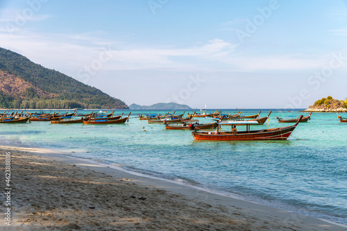 Wooden long-tail boat anchored on the beach in tropical sea at Koh Lipe