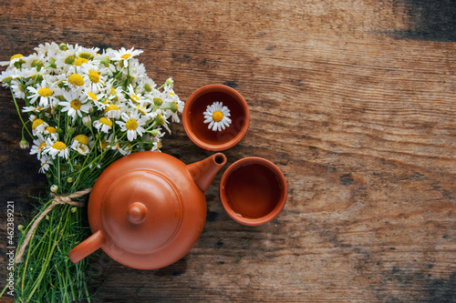 cup of herbal chamomile tea with fresh daisy flowers background, treatment and prevention of immune concept 