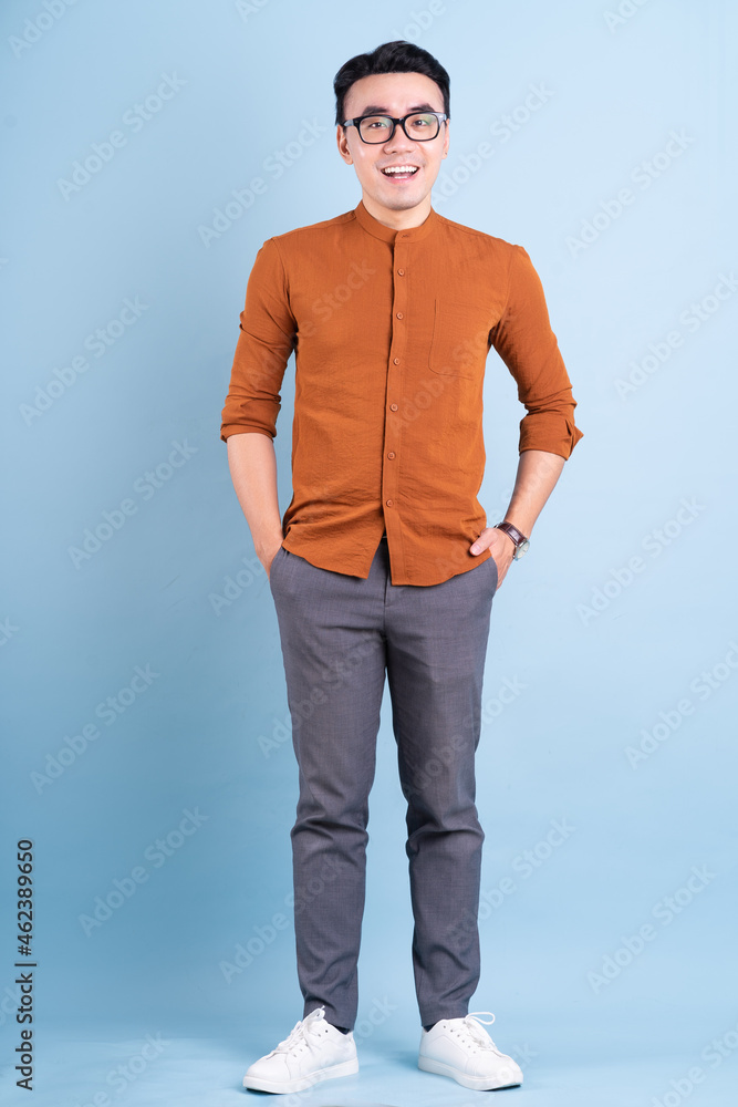 Young Asian businessman posing on blue background Young Asian businessman posing on blue background