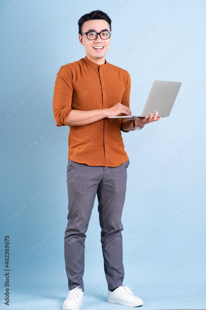 Young Asian businessman posing on blue background Young Asian businessman posing on blue background