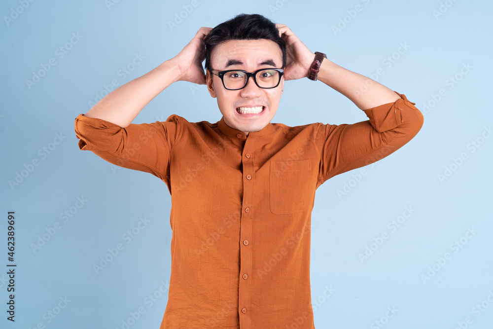 Young Asian businessman posing on blue background Young Asian businessman posing on blue background