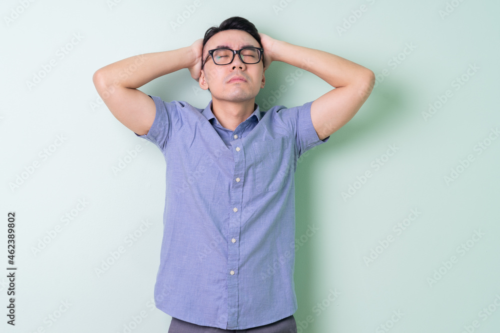 Young Asian businessman posing on green background Young Asian businessman posing on green background