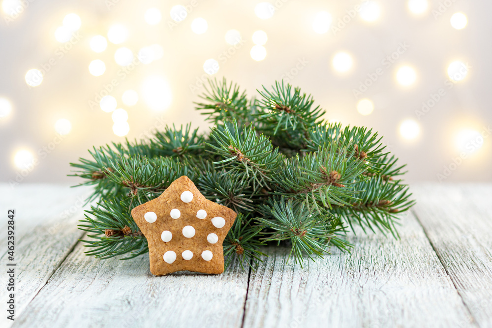 Gingerbread star with fir tree branch on bokeh lights background Gingerbread star with fir tree branch on bokeh lights background